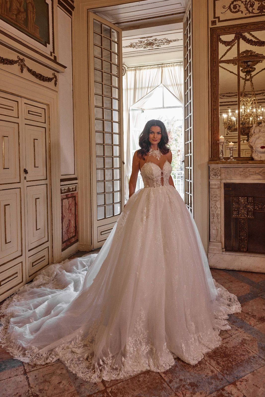 Una donna in abito da sposa è in piedi davanti a una porta in una stanza.