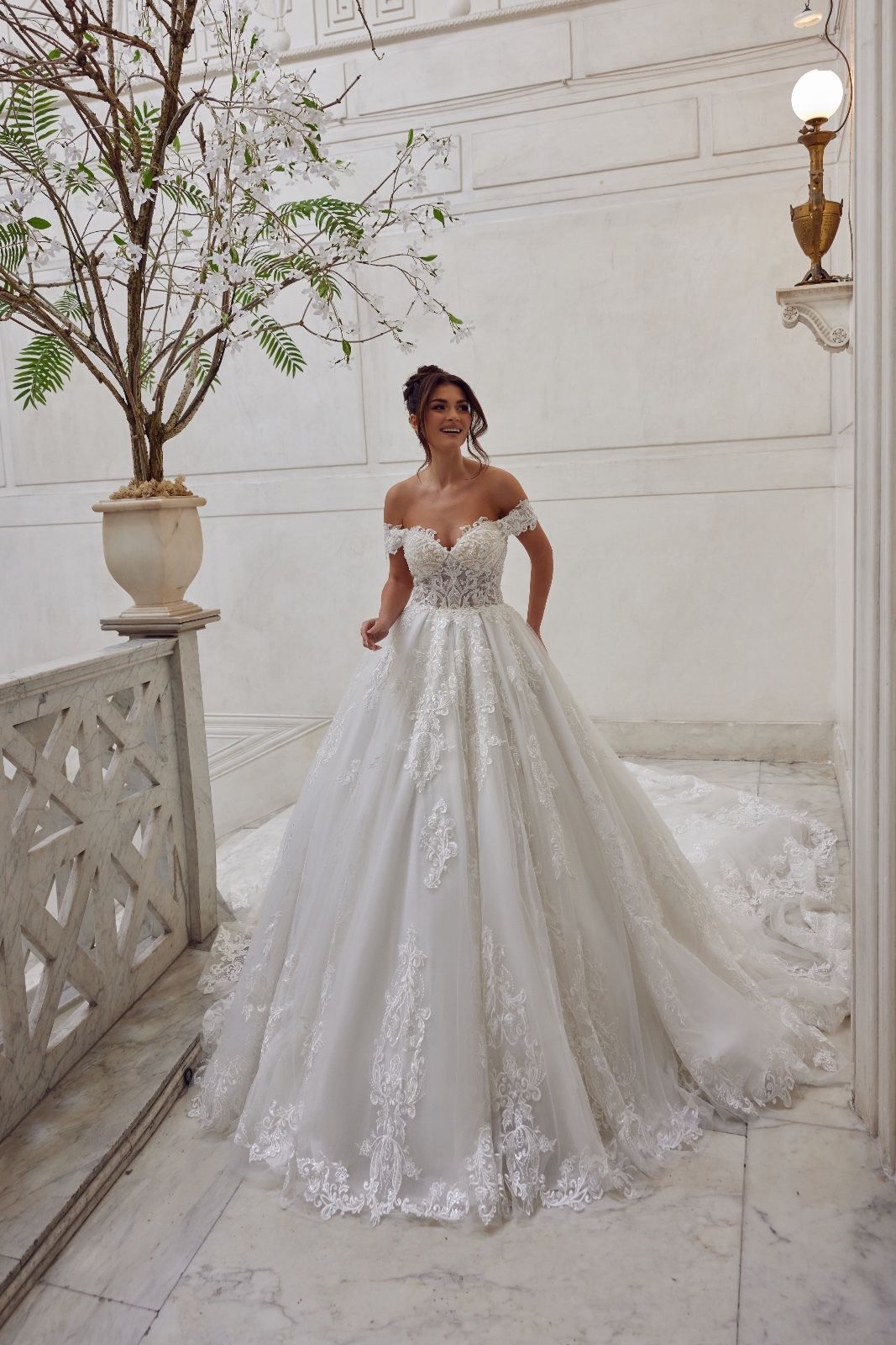 Una donna con un abito da sposa bianco è in piedi davanti a un edificio.