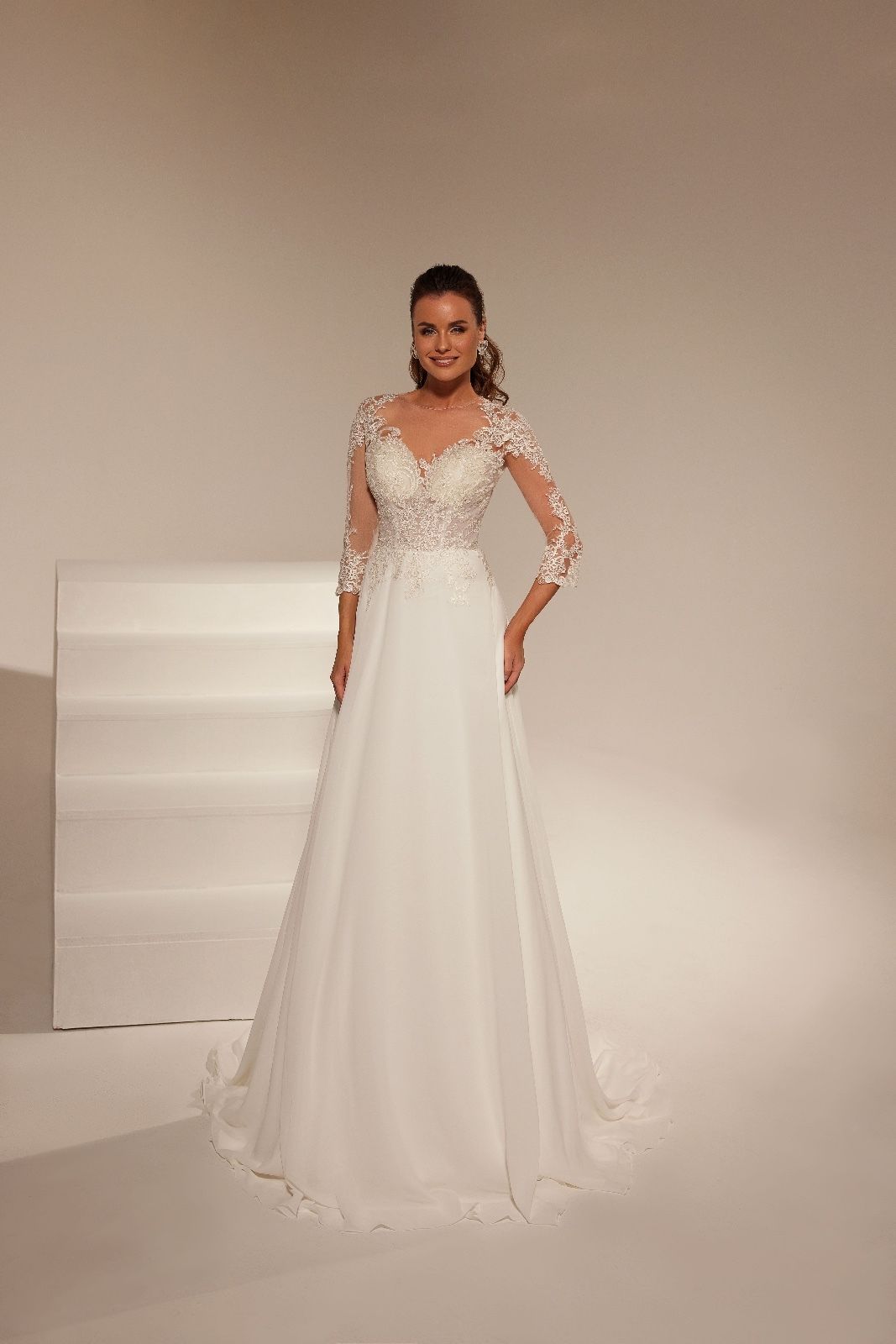 Una donna indossa un abito da sposa bianco con maniche lunghe.