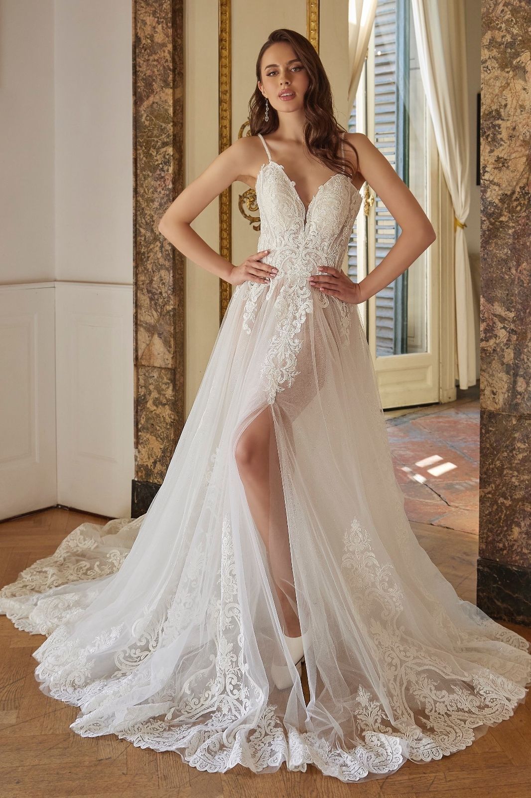 Una donna indossa un abito da sposa bianco con uno spacco profondo.