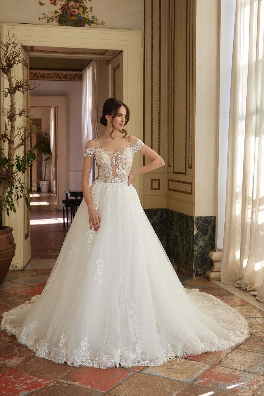 Una donna in abito da sposa bianco è in piedi in un corridoio.