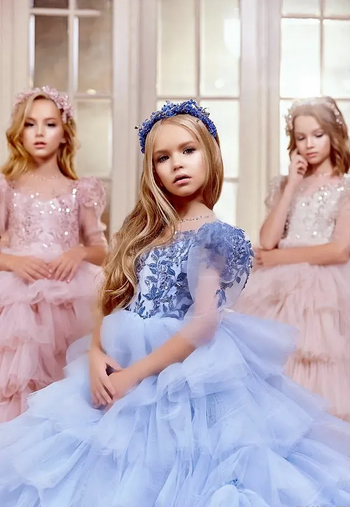 Una bambina con un vestito rosa è in piedi in una stanza piena di fiori.