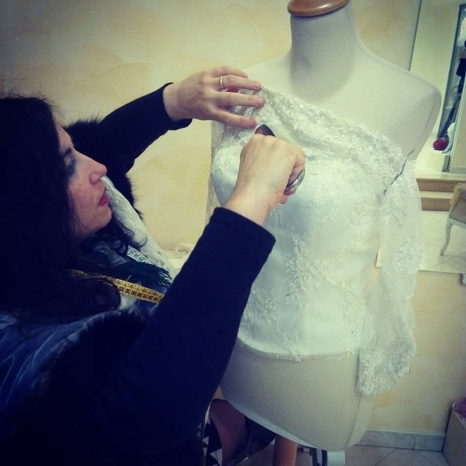 Una donna sta usando un righello per misurare un pezzo di carta su un tavolo.