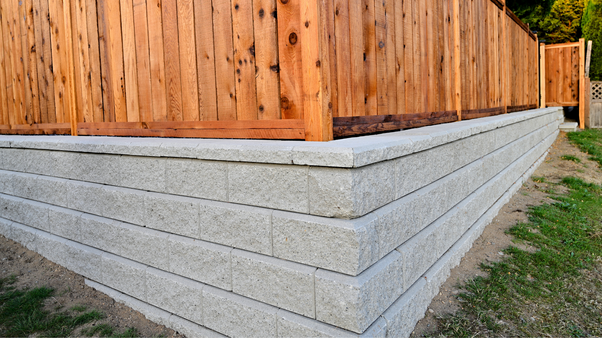 a large rock retaining wall built alongside an asphalt driveway