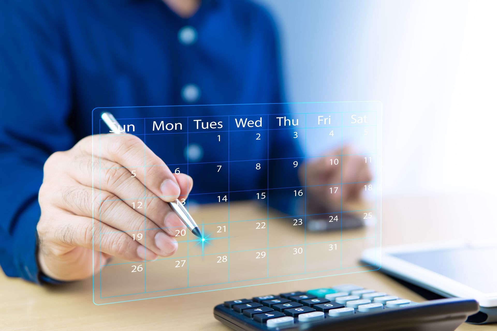 An accountant working with a virtual calendar and a calculator on his desk. An accountant working with a virtual calendar and a calculator on his desk.