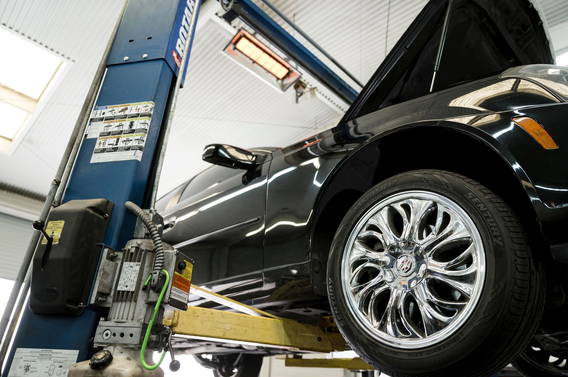 Black Car on a Lift in Our Service Center in Fresno, CA - Electric Laboratories Complete Car Care