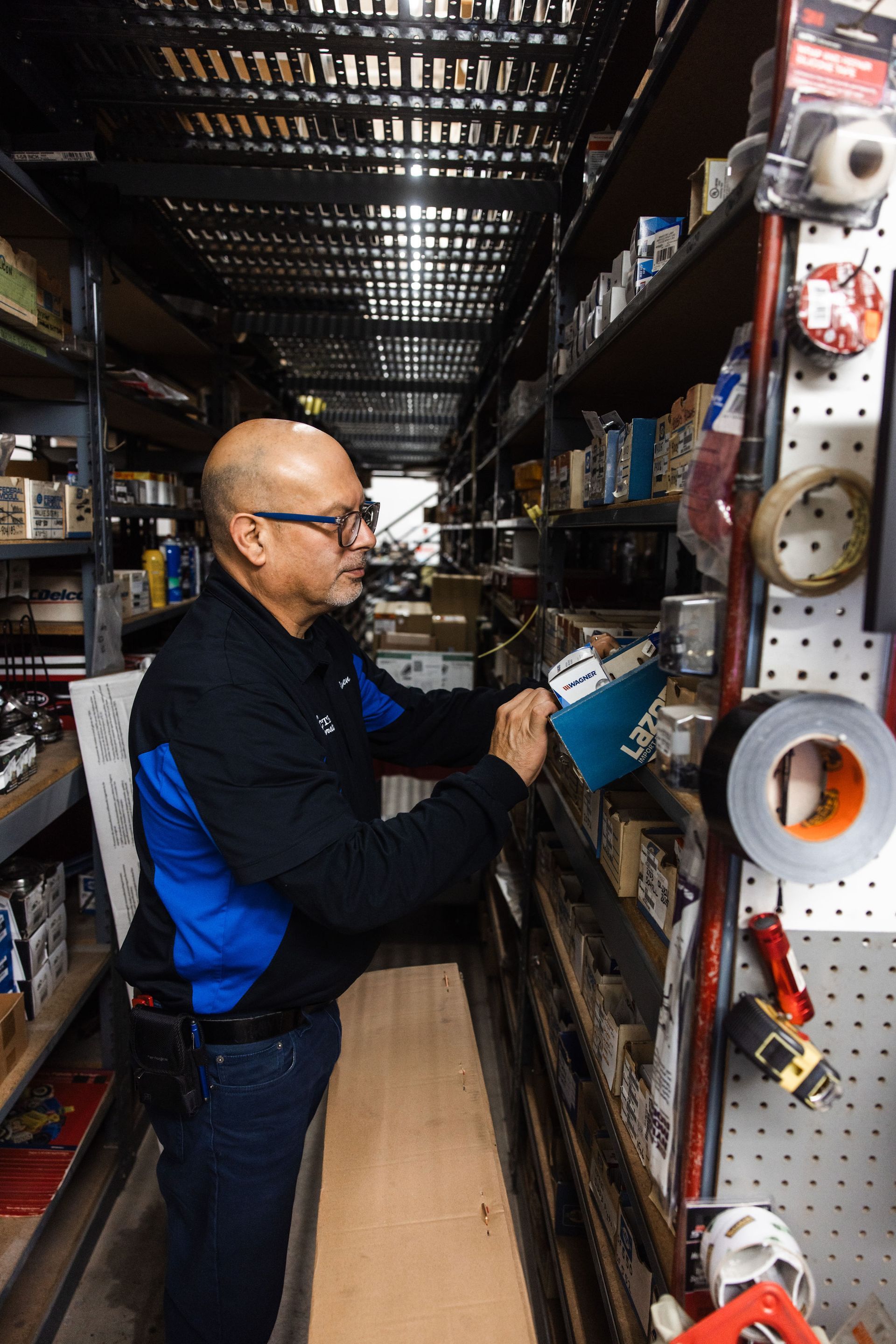 Our Mechanic Checks The Auto Repair Shop's Inventory - Electric Laboratories Complete Car Care