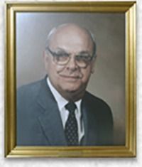 Man in glasses and suit, framed portrait.
