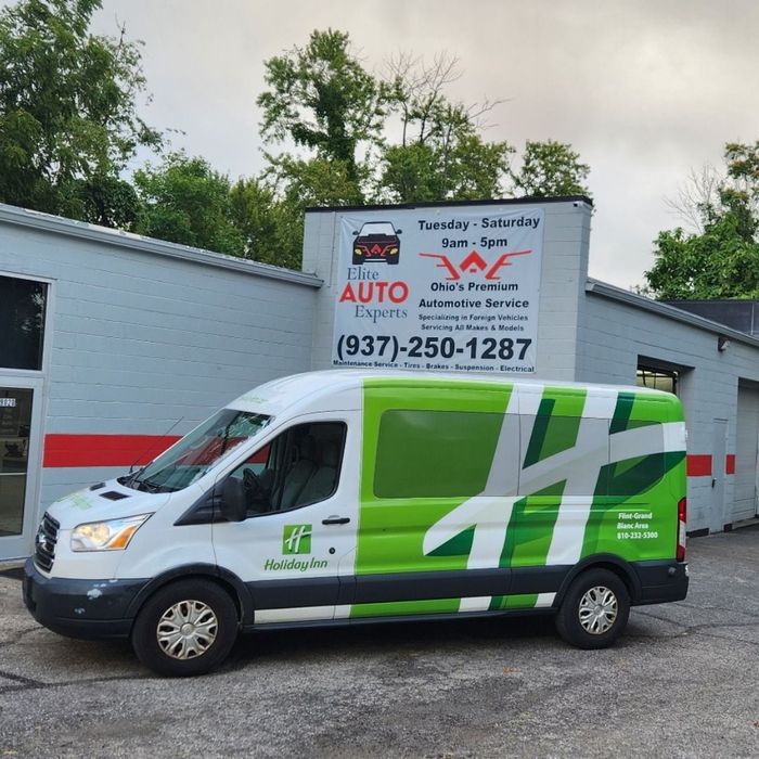 A car is parked in front of a car dealership.