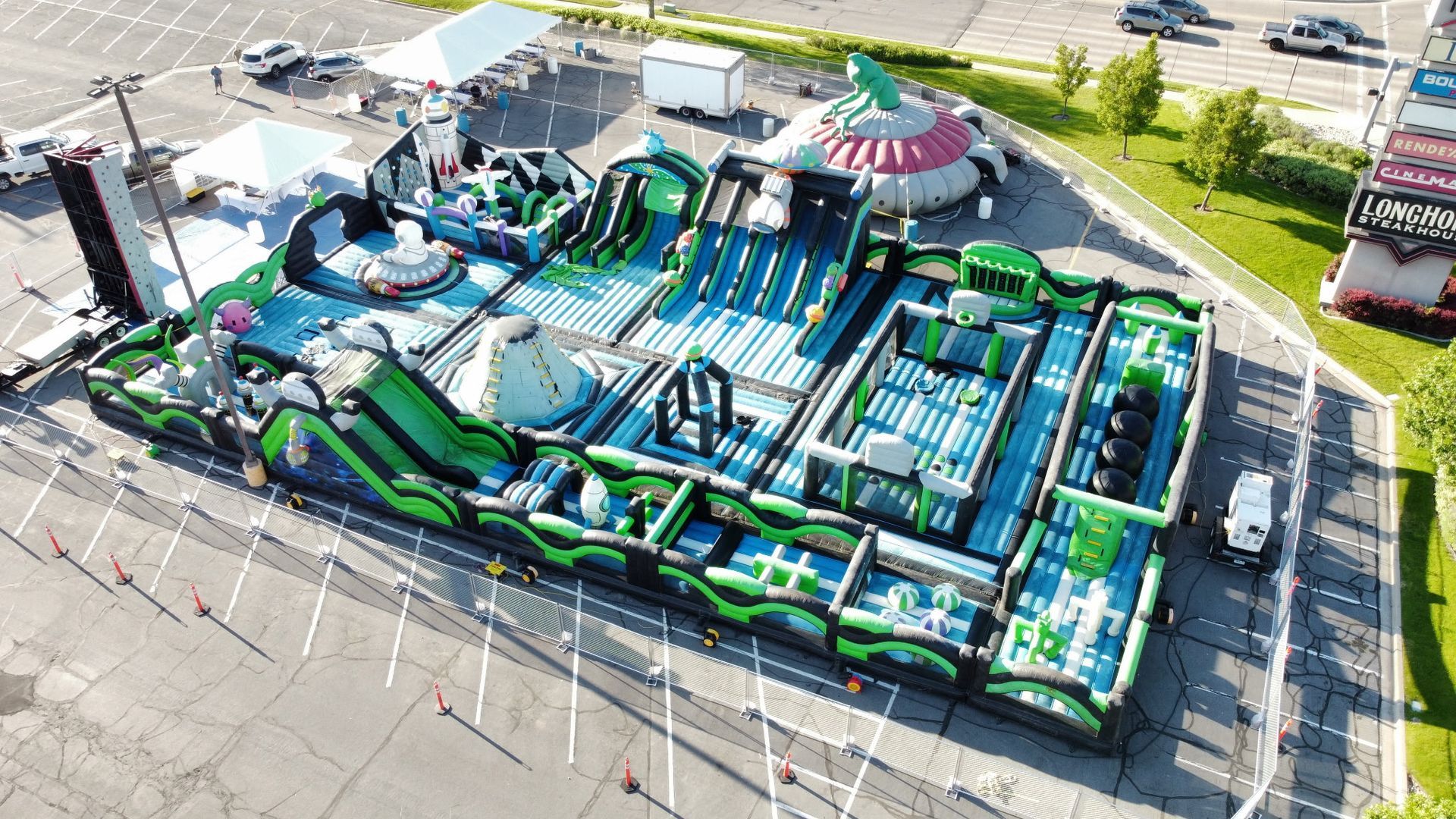 An aerial view of a large inflatable water park in a parking lot.