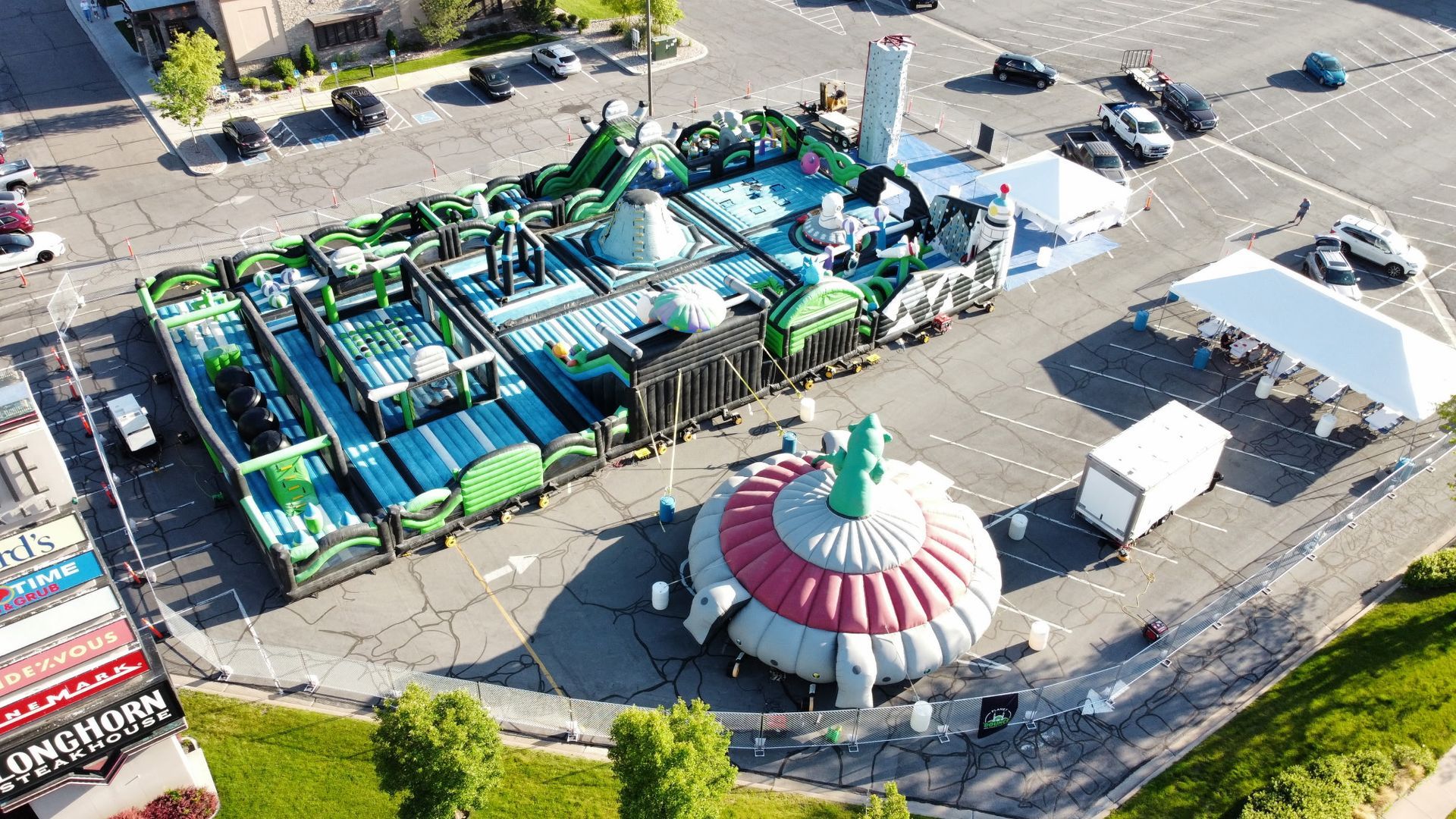 An aerial view of a large inflatable water park in a parking lot.