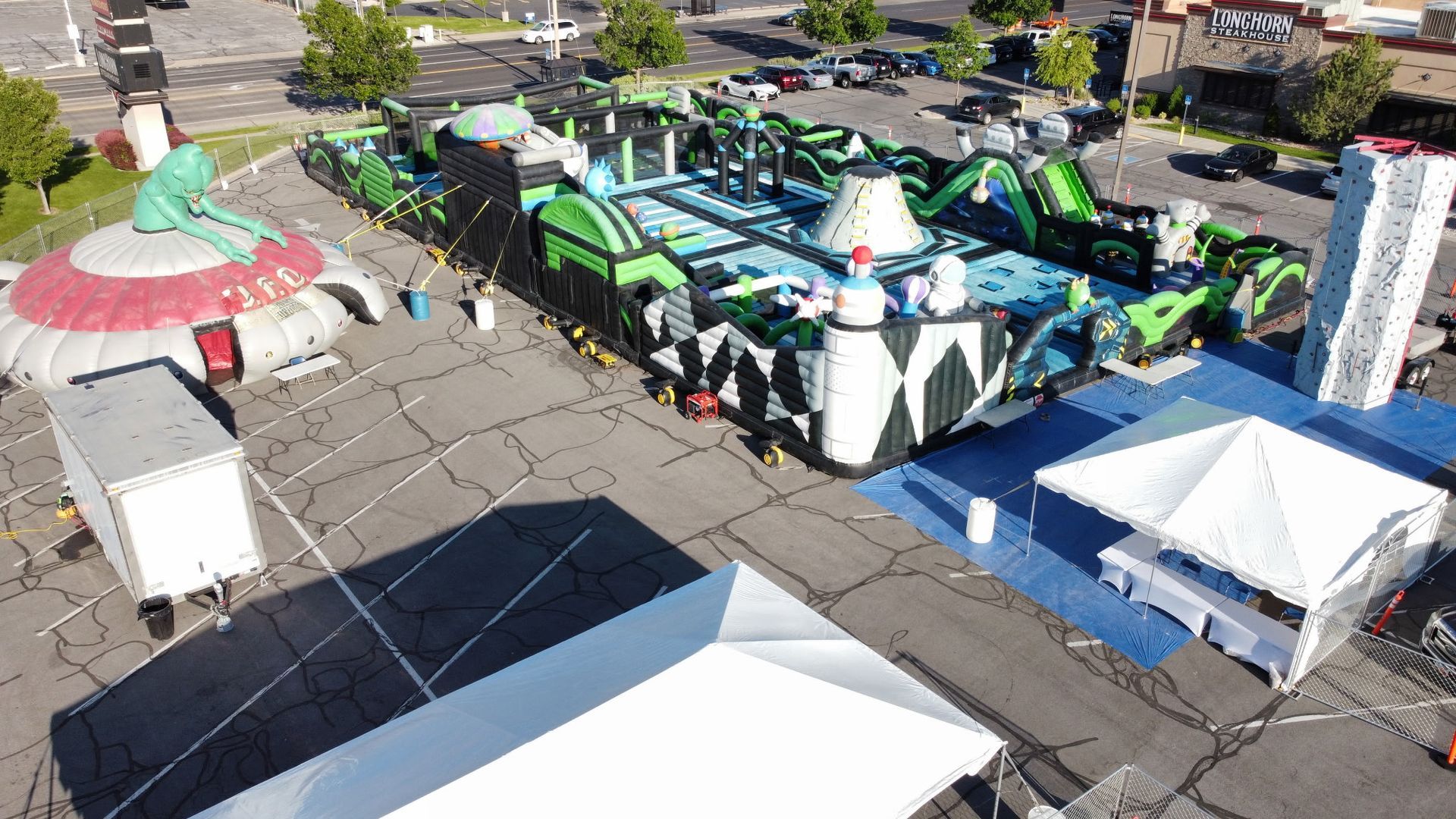 An aerial view of a large inflatable obstacle course in a parking lot.
