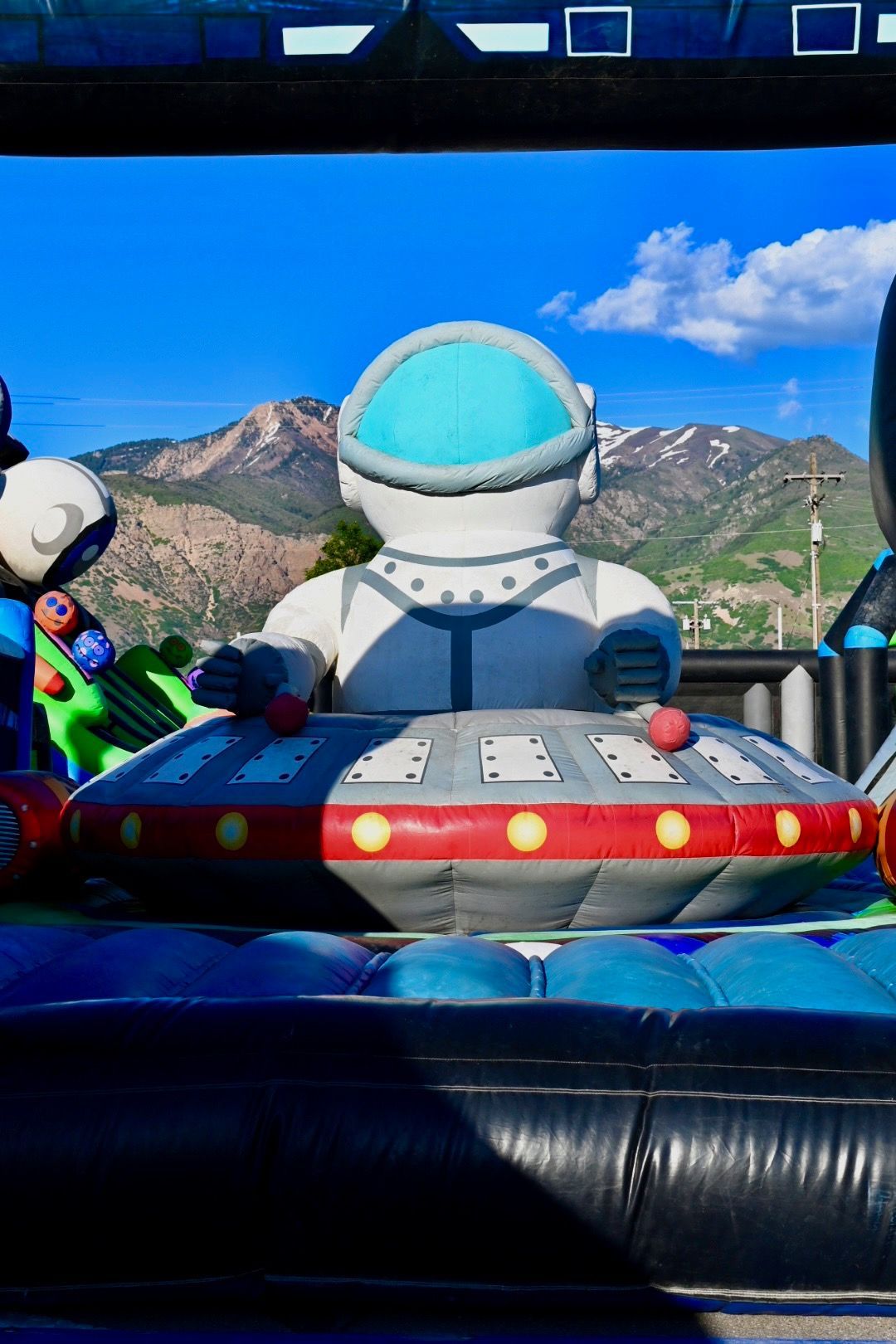 A giant inflatable astronaut is sitting on top of an inflatable ufo.