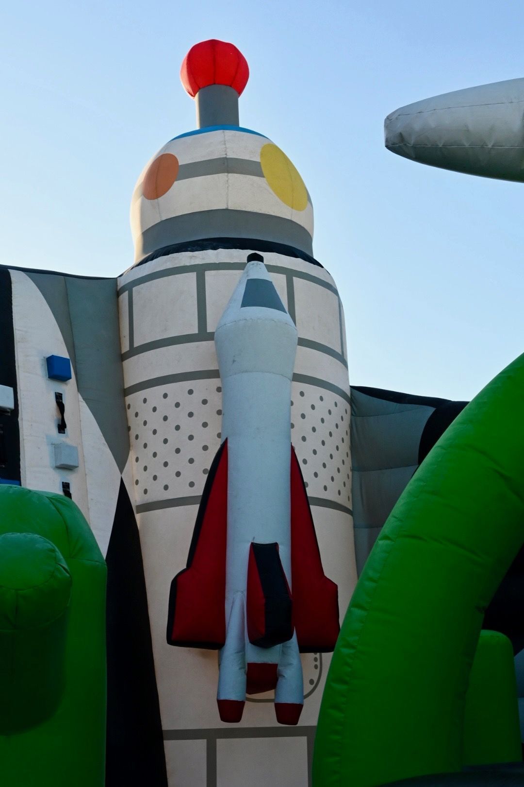 A large inflatable rocket is sitting on top of an inflatable building.