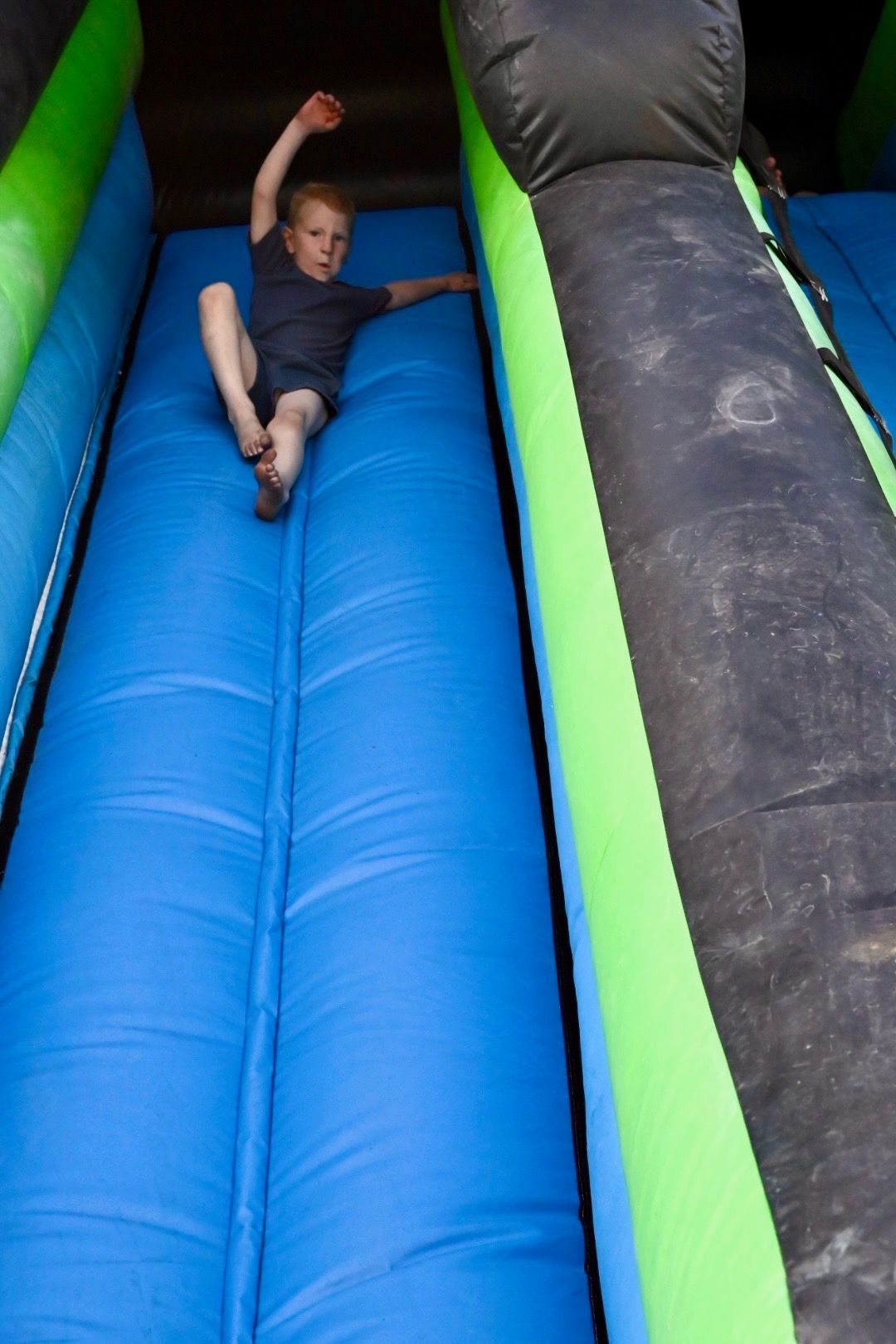 A young boy is sliding down an inflatable slide.