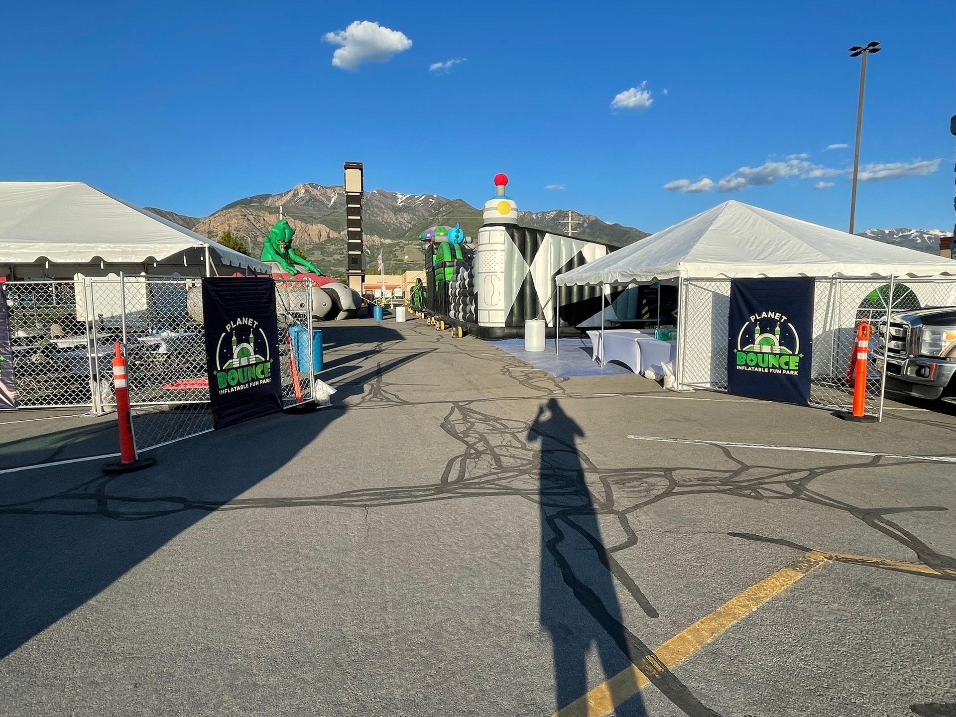 A shadow of a person is cast on the ground in a parking lot.