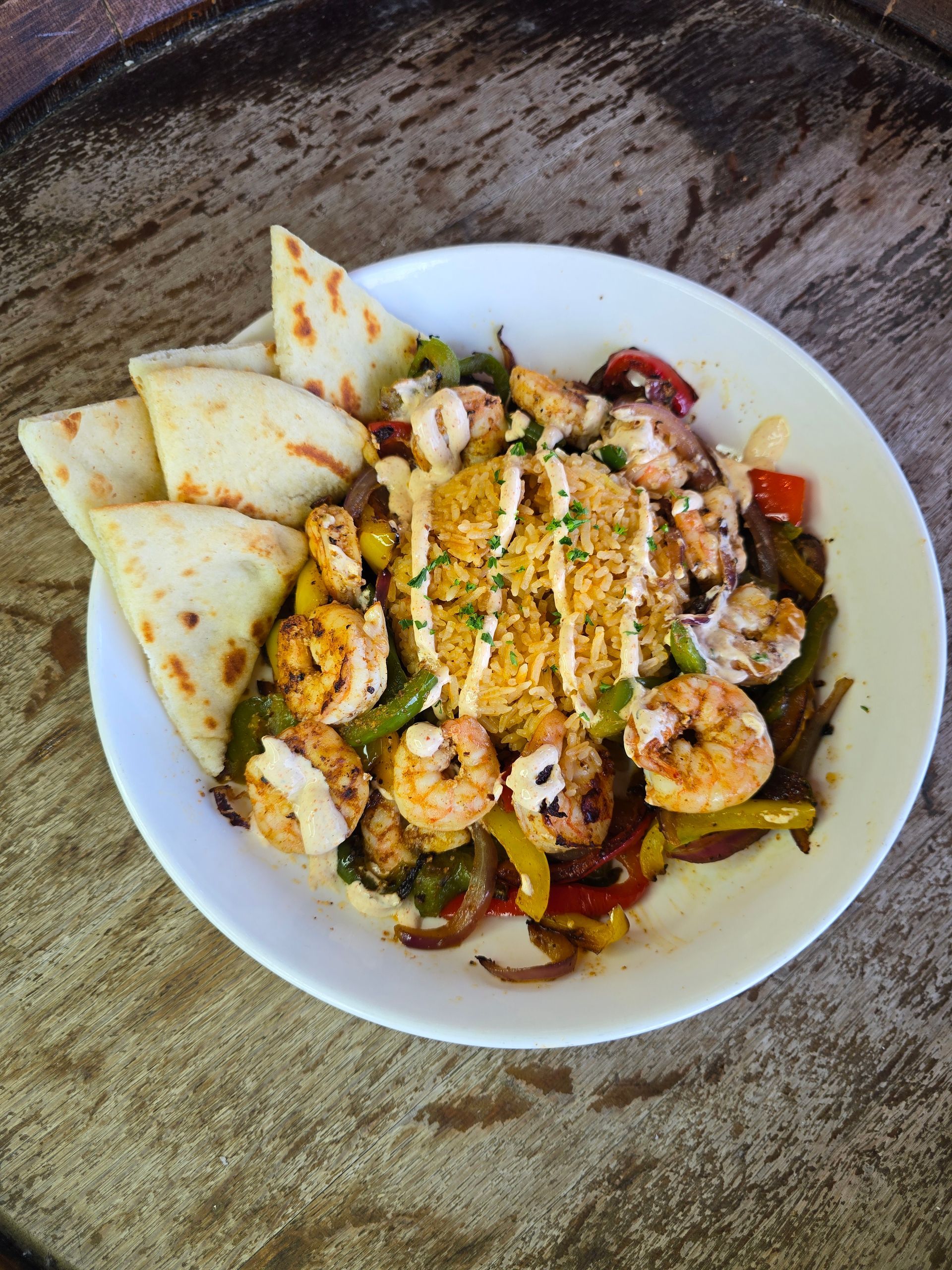 Plate of shrimp fajitas with tortillas, rice, and peppers.