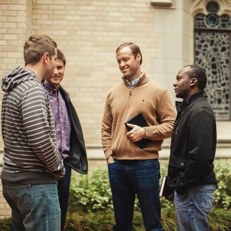 A group of men are standing outside talking to each other