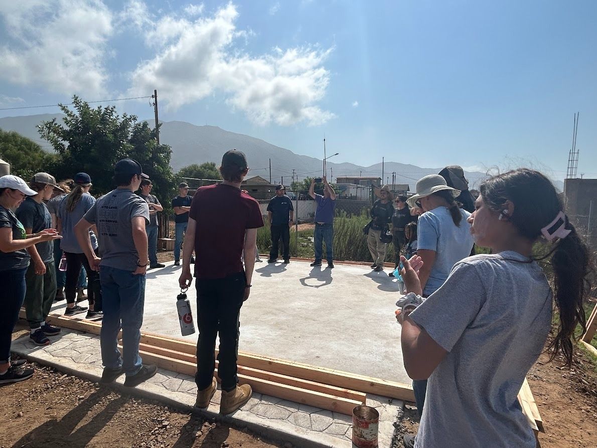 A group of people are standing in a circle on a construction site.