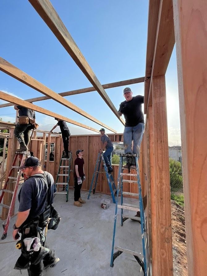 A group of men are working on a wooden structure.