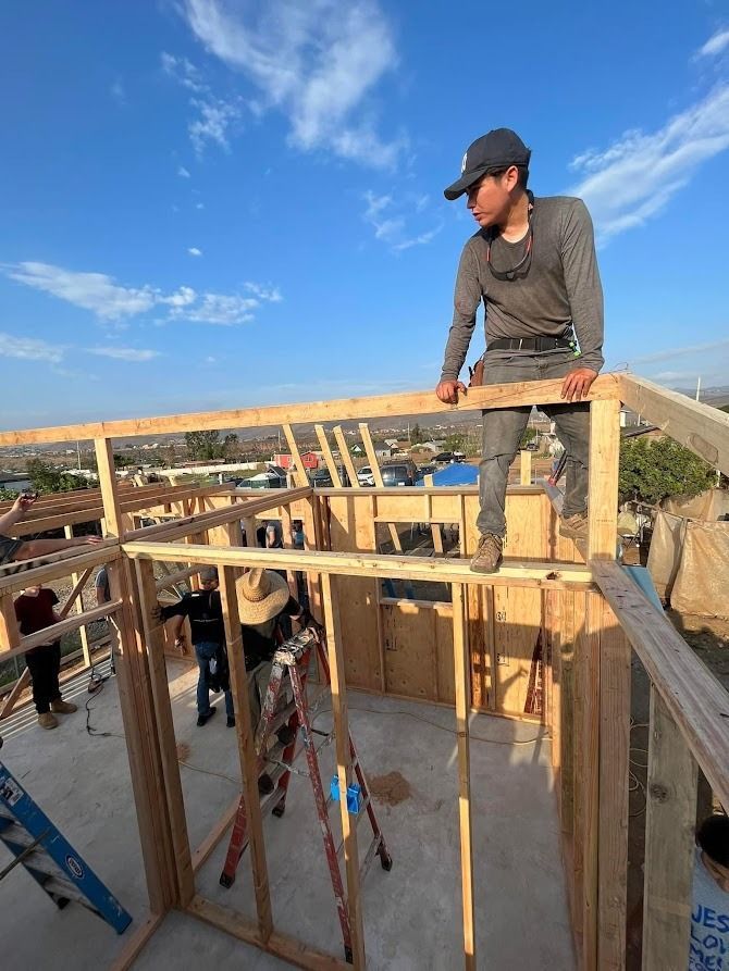 A man is standing on top of a wooden structure.
