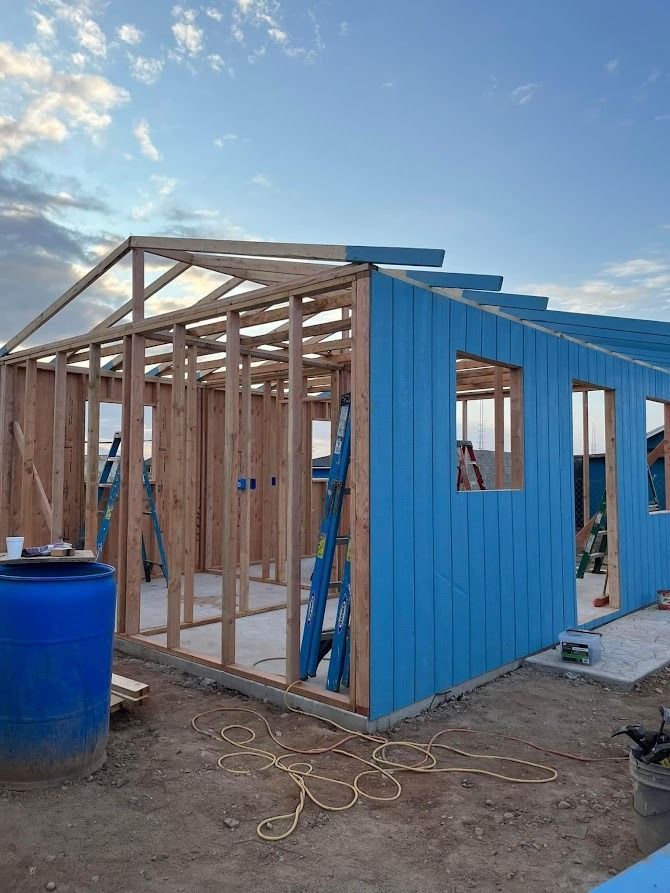 A blue house is being built in the desert