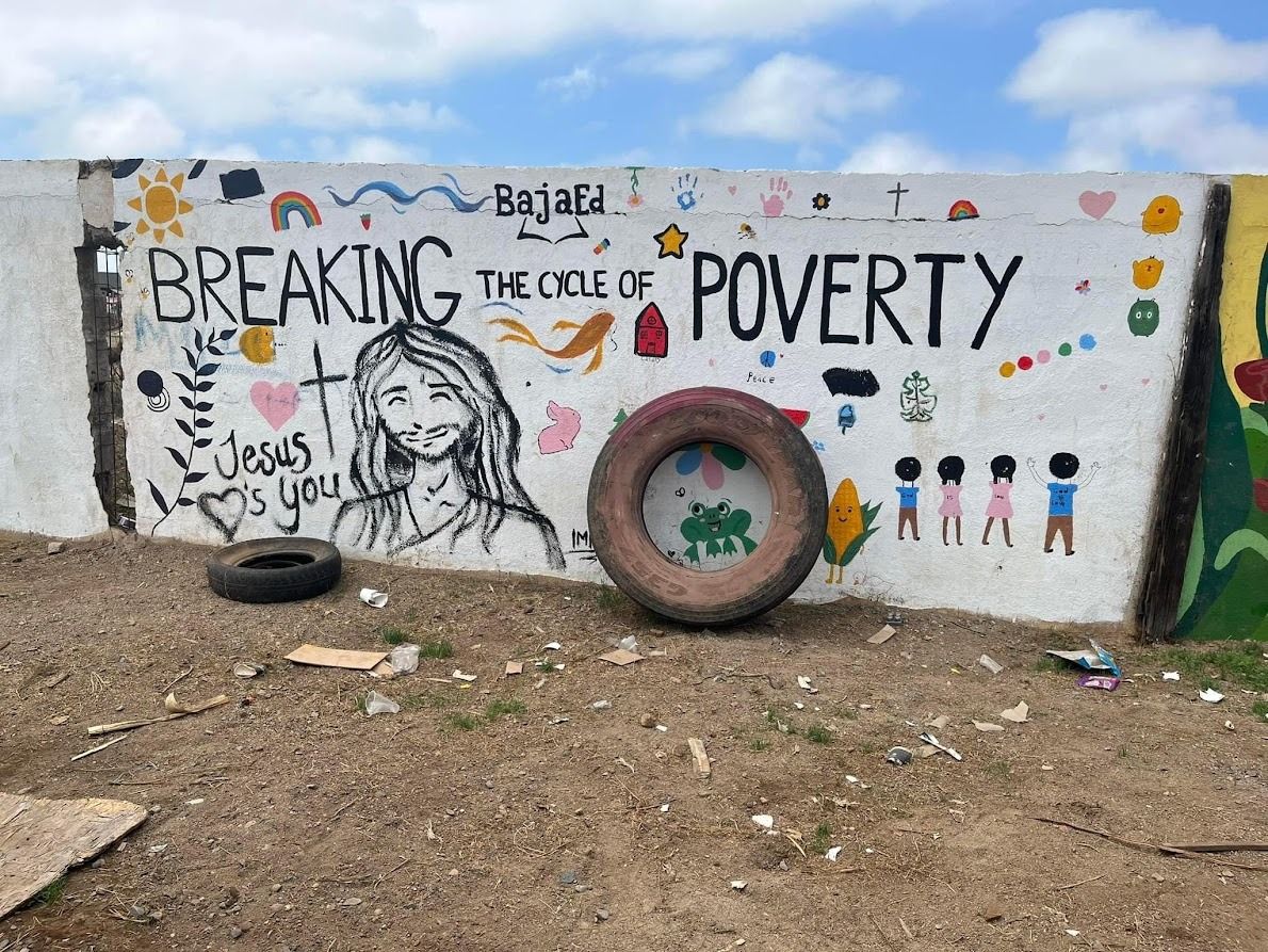 A wall with graffiti on it that says `` breaking the cycle of poverty ''.