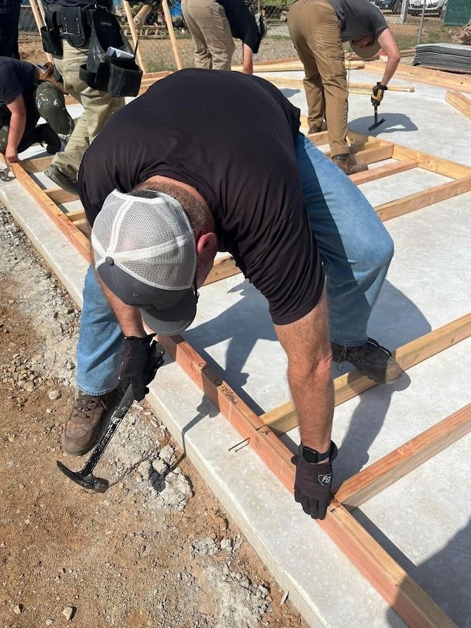 A group of construction workers are working on a concrete floor.