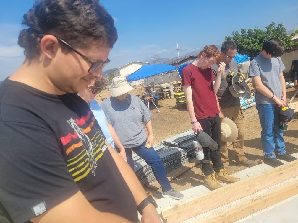 A group of people are standing in a row in a field.