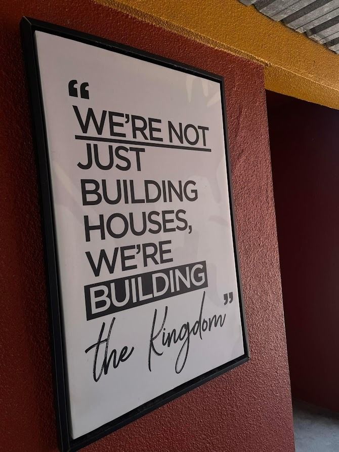 A sign that says we 're not just building houses we 're building the kingdom