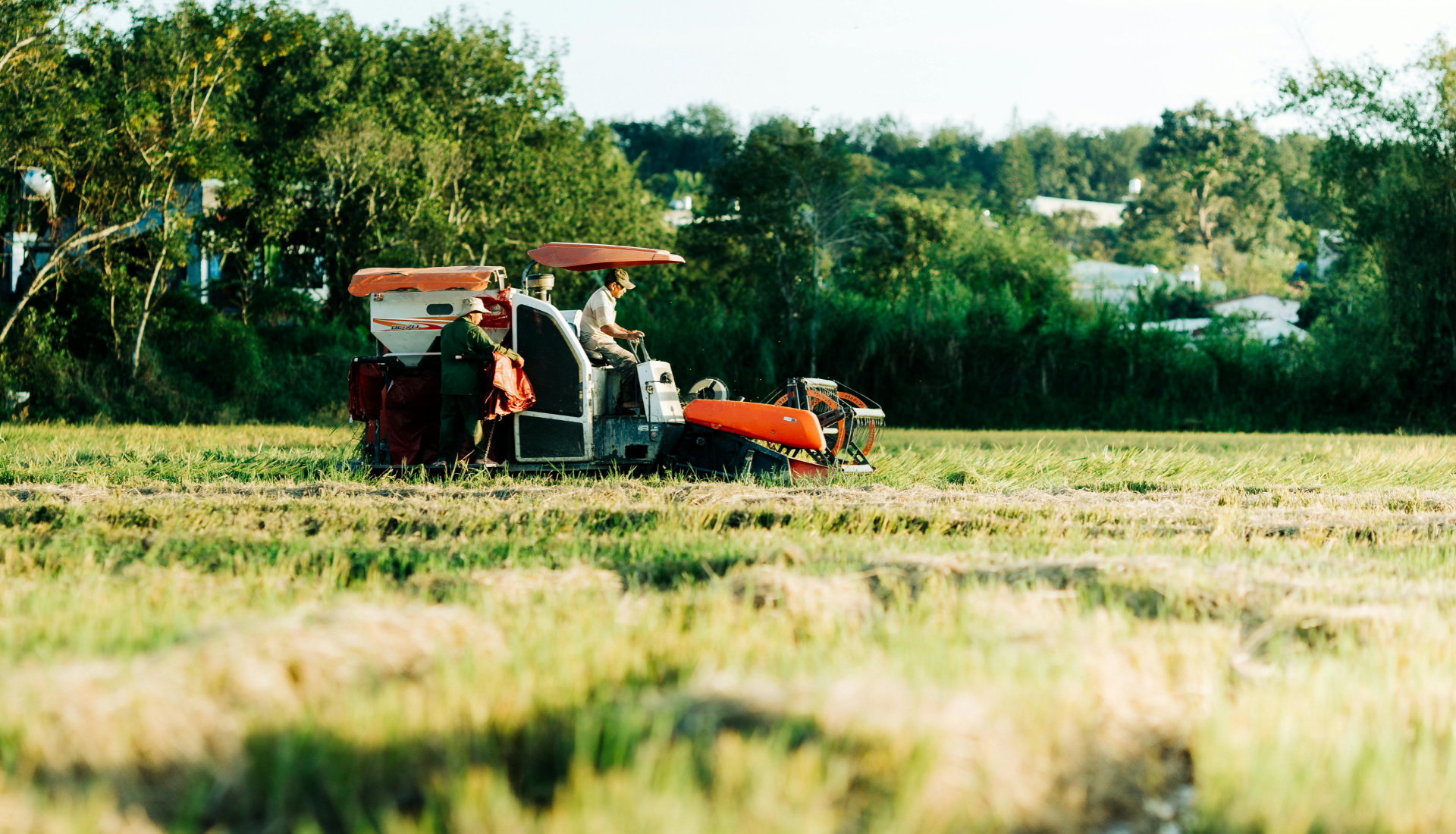 A barista taking an order from two customers at a cafe counter.