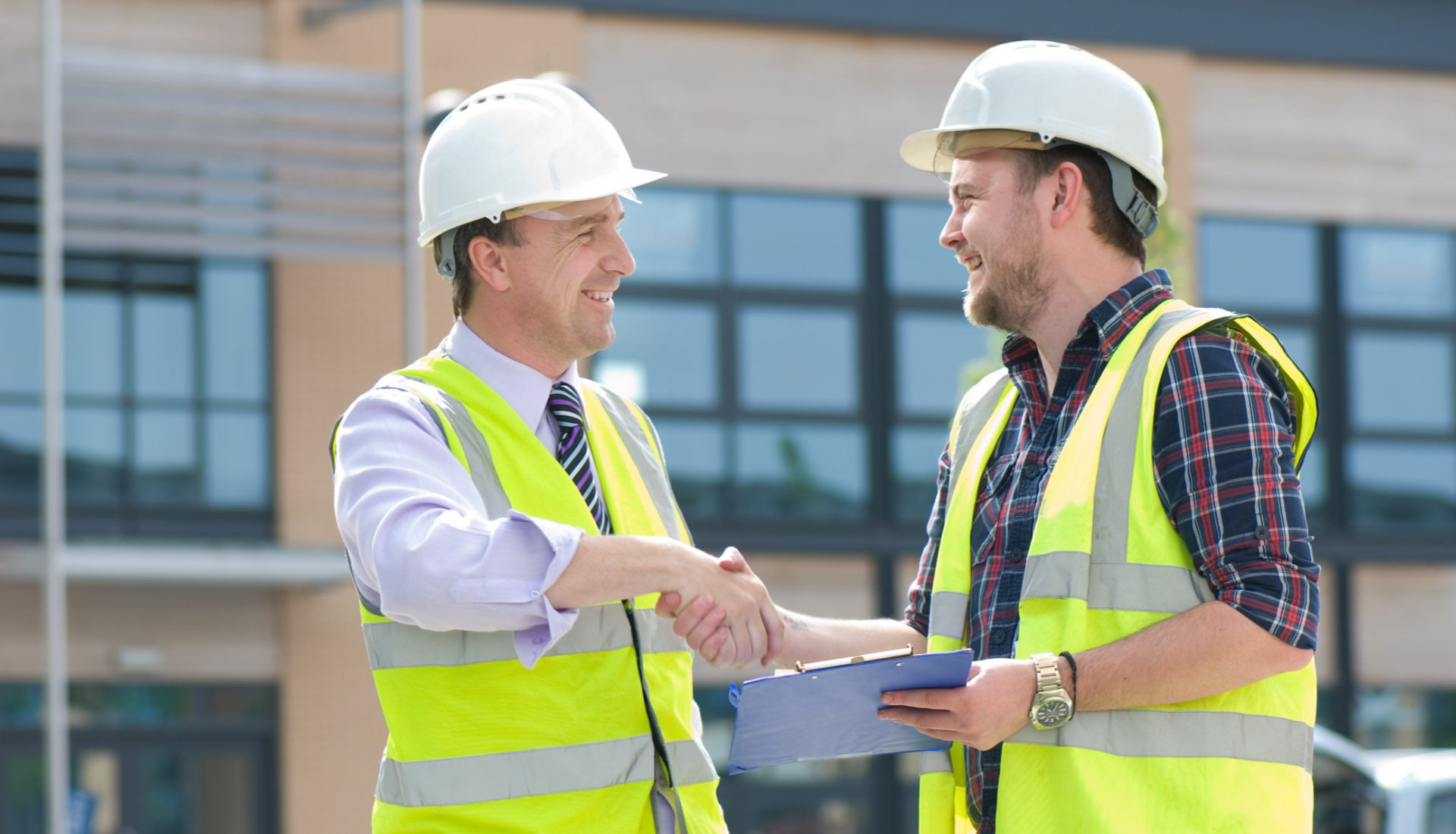 Smiling couple under a yellow and white umbrella, outdoors in a garden setting.