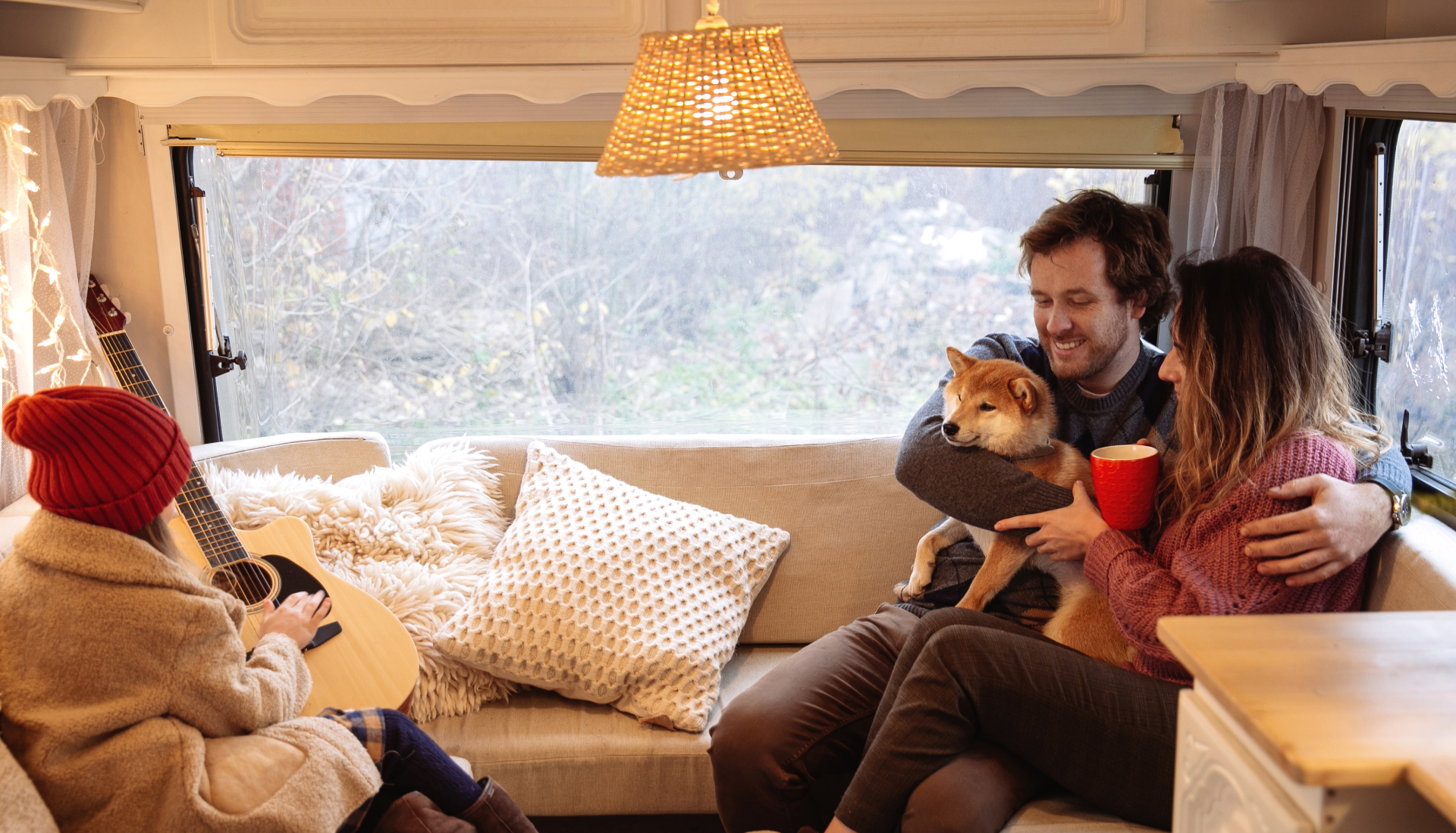 Family outdoors, smiling and talking; man gesturing, elderly man sitting, young girl, and blonde women.