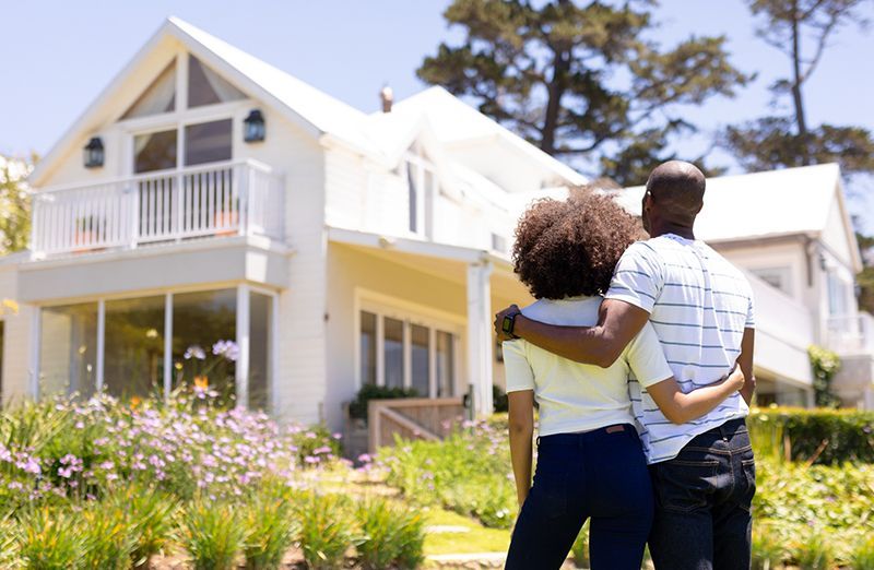 A woman is sitting at a desk with a computer and a sign that says ksw