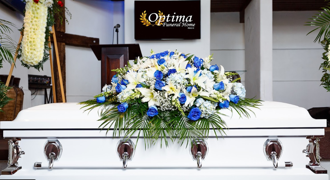 A white coffin with blue and white flowers on it