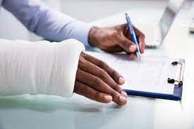 close up of hands hands with cast filling out workers compensation insurance