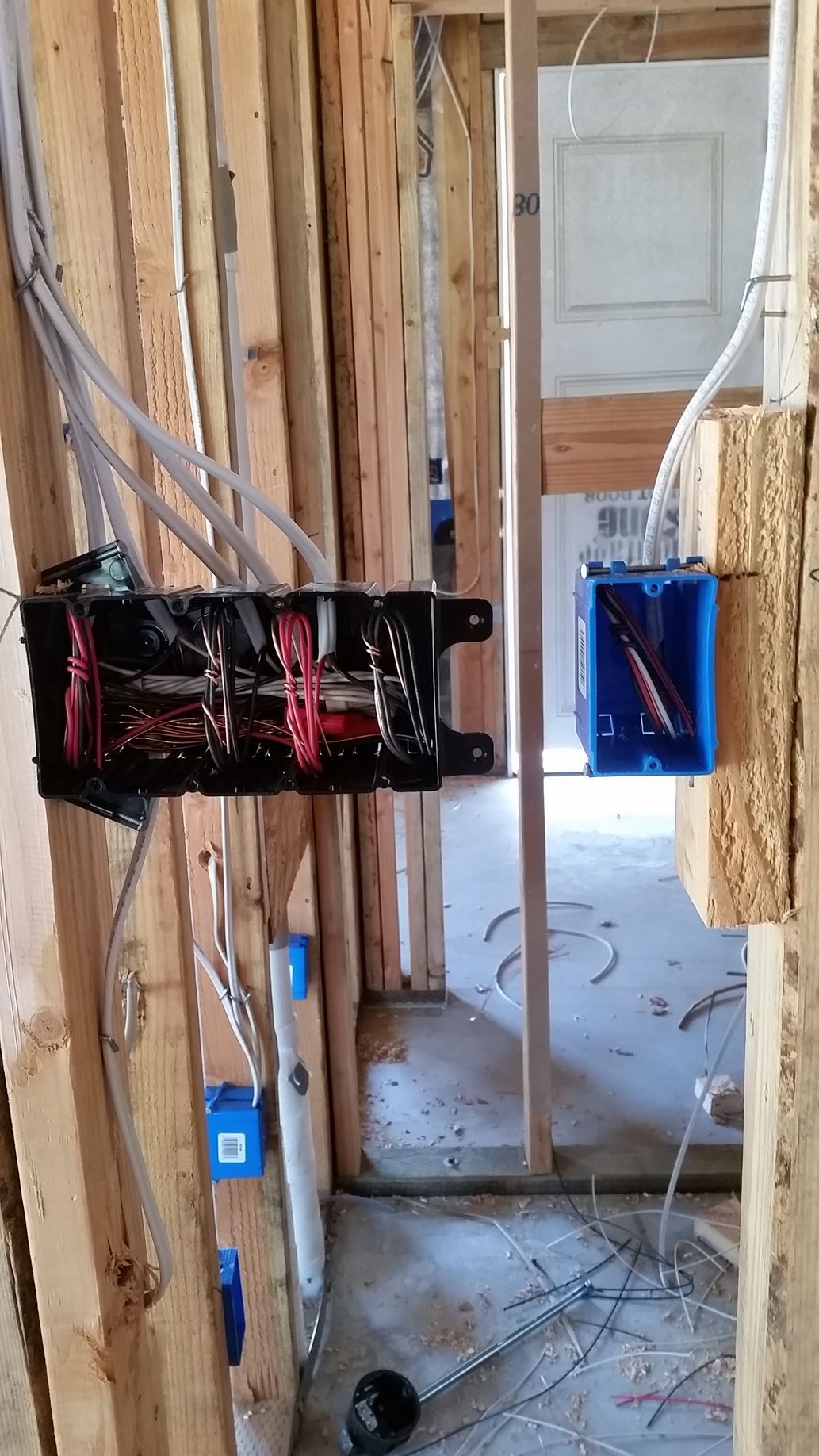 Ground-up home wiring in progress with exposed cables and outlet boxes in wood framing