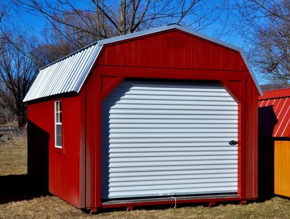 A Red Barn With A White Garage Door And A Window — The Roller Door Man NQ In Portsmith, QLD