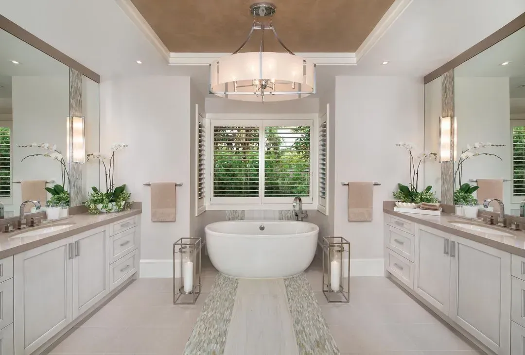Luxury bathroom with a freestanding tub, dual vanities, and a chandelier.
