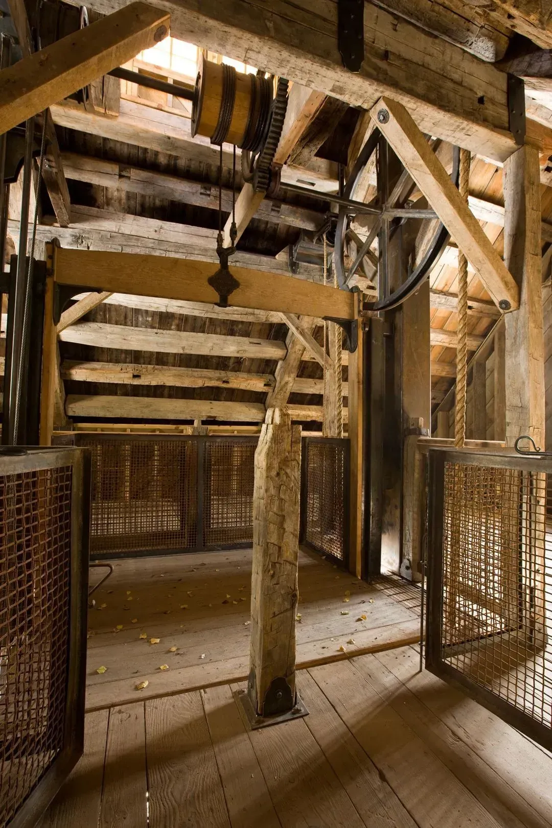 Wooden structure interior with gears and cage elevators.
