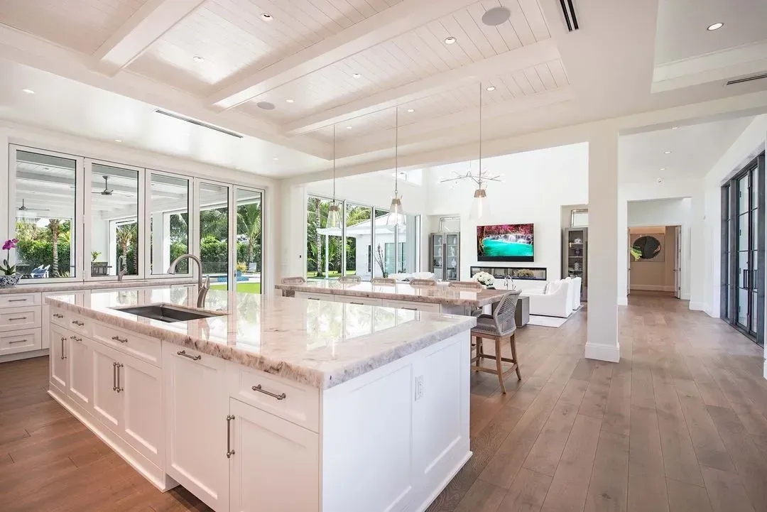 Bright, modern kitchen with a large island and open view to living area and outdoor space.