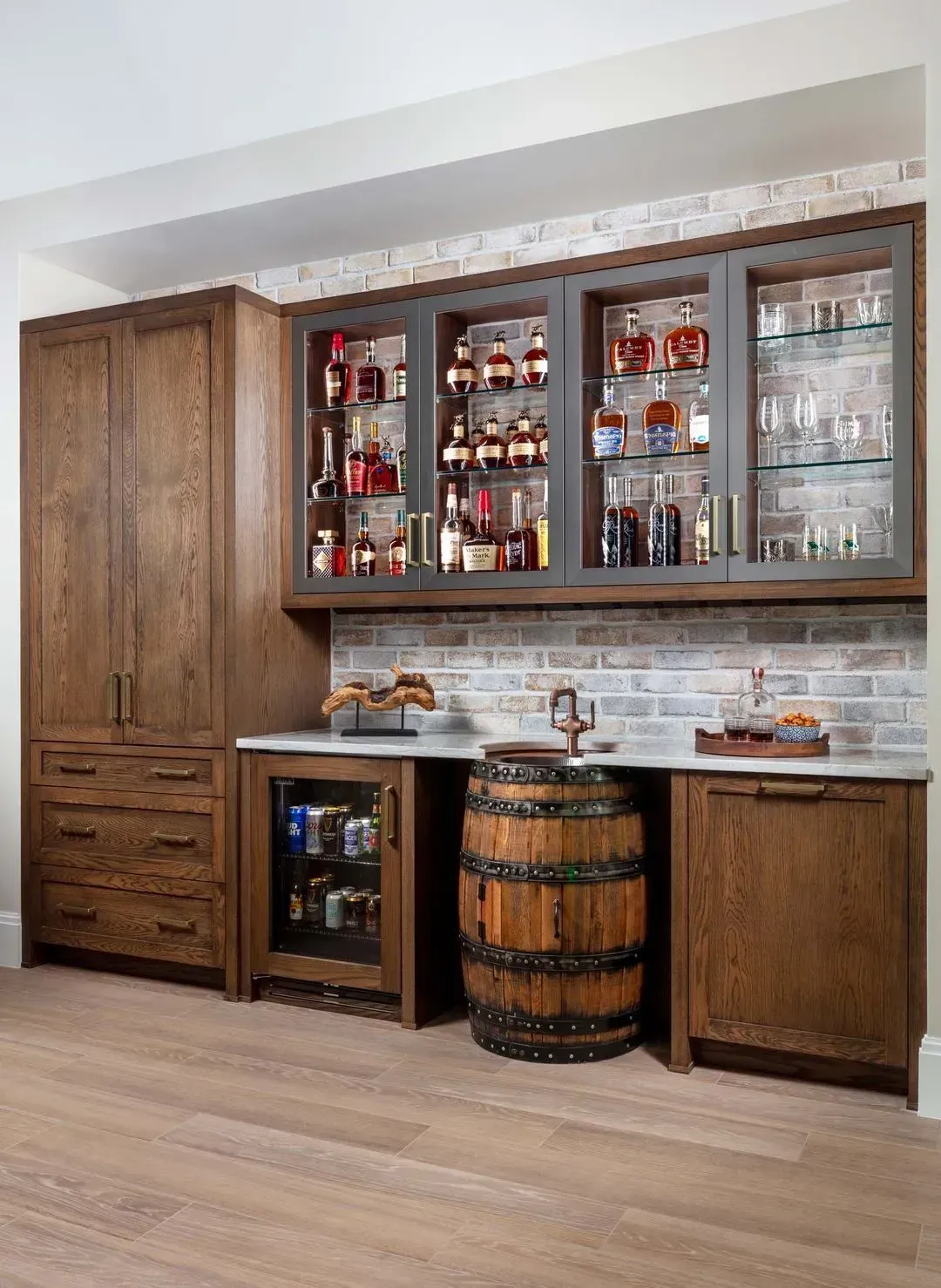 Built-in home bar with wood cabinetry, a liquor display, a mini-fridge, and a barrel.