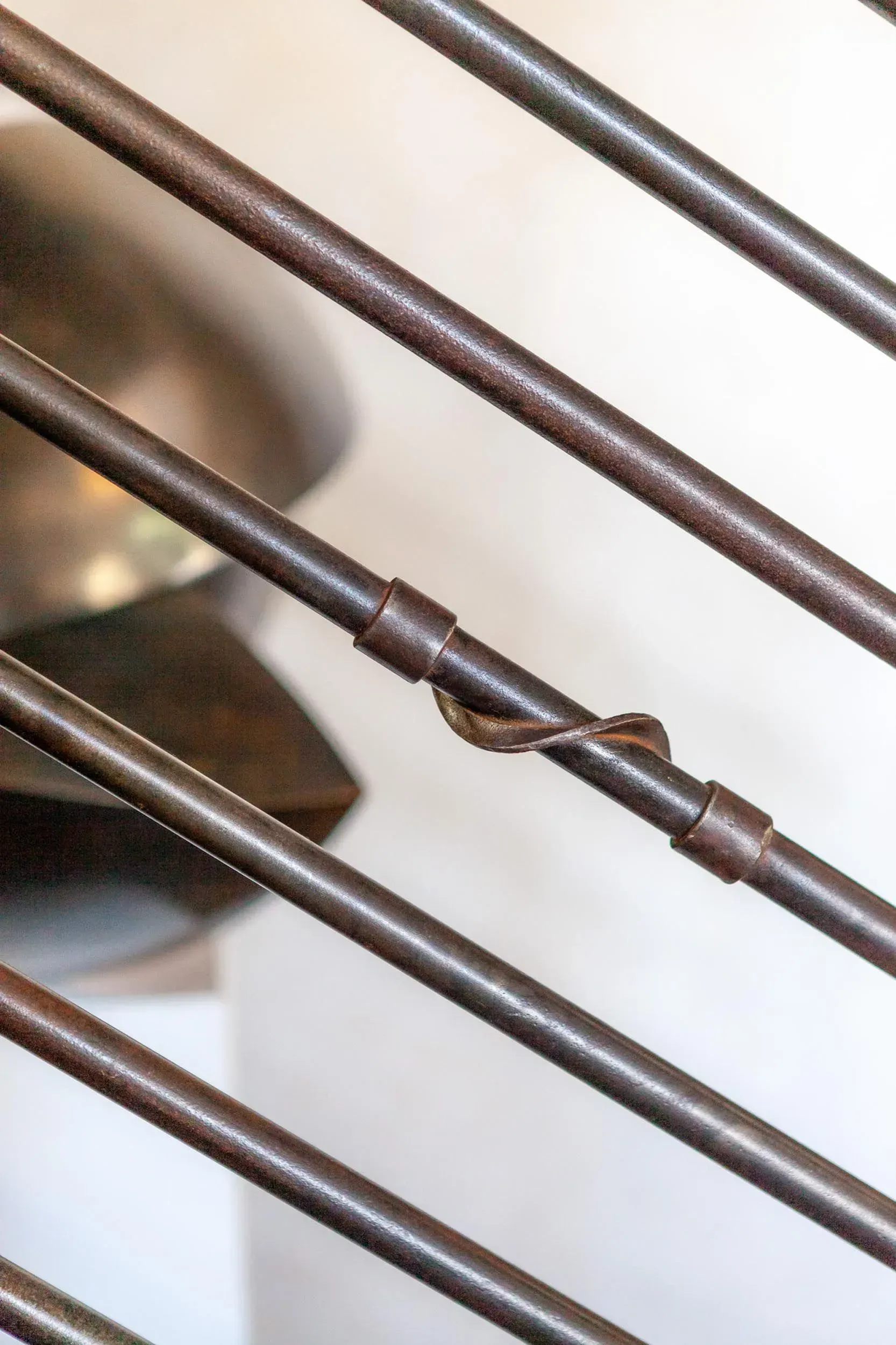 Close-up of metal rods with a spiral detail, angled against a white background.