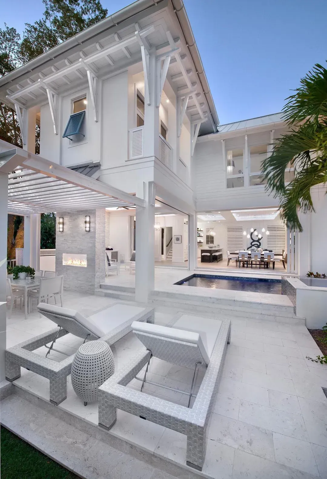White luxury home with pool, outdoor seating, and open layout.