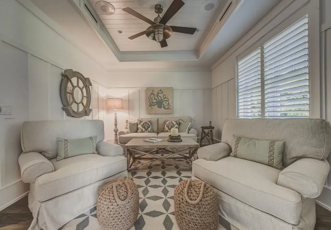 Cozy living room with white couches, a decorative coffee table, and patterned rug.