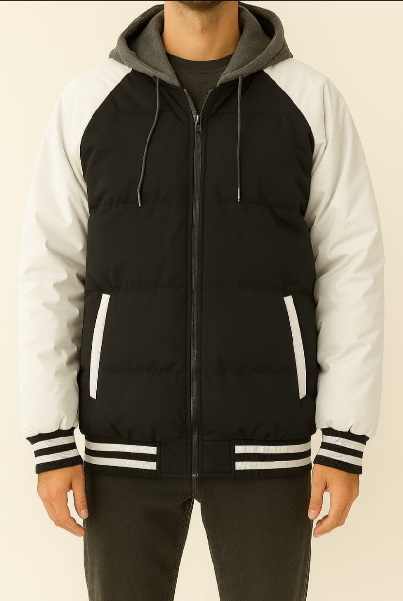 Chaqueta acolchada negra con mangas y capucha grises en una persona.