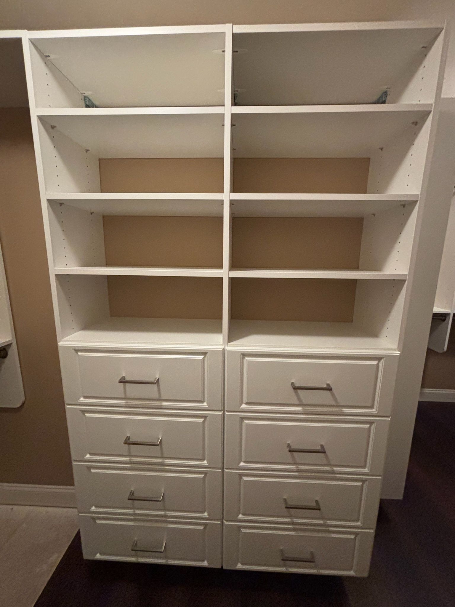 A white closet unit with two side-by-side towers, each featuring four open shelves on top and four drawers below.