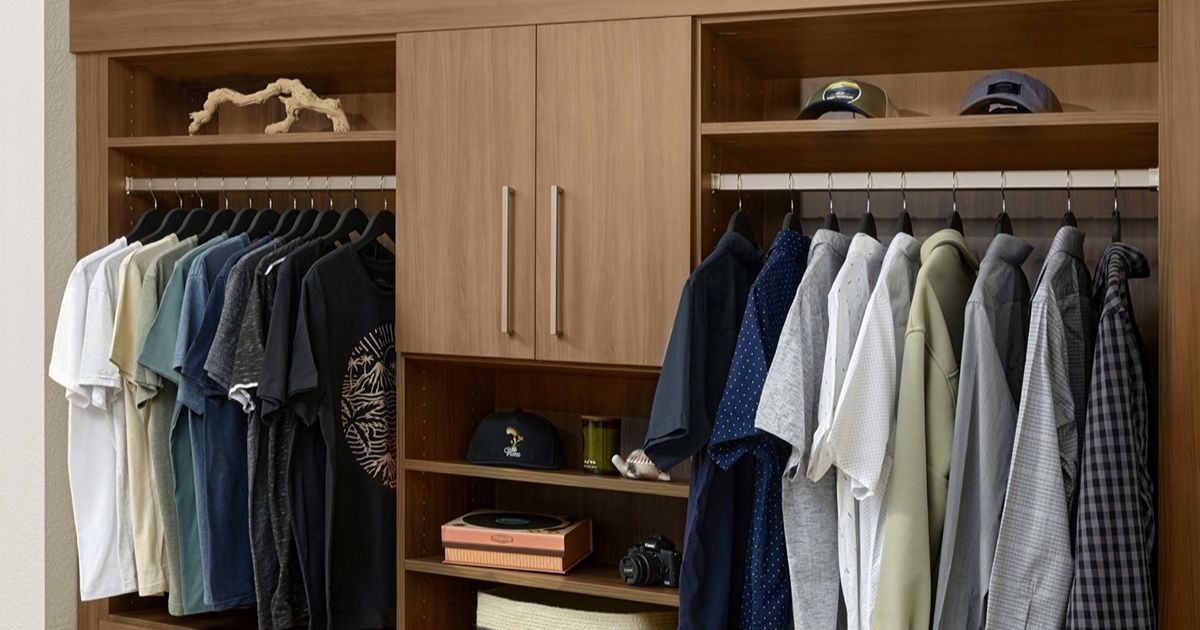 Wooden closet with hanging clothes, hats, and shelves.