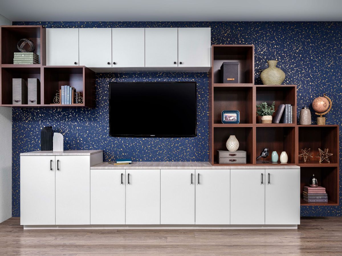 A well-organized walk-in closet with teal cabinetry and white shelving. Clothes hang, and decorative items are on display.