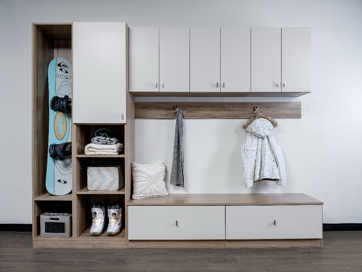 A reach in closet with gray shelving, drawers, and hanging rods for clothes. Clothing is organized by color.